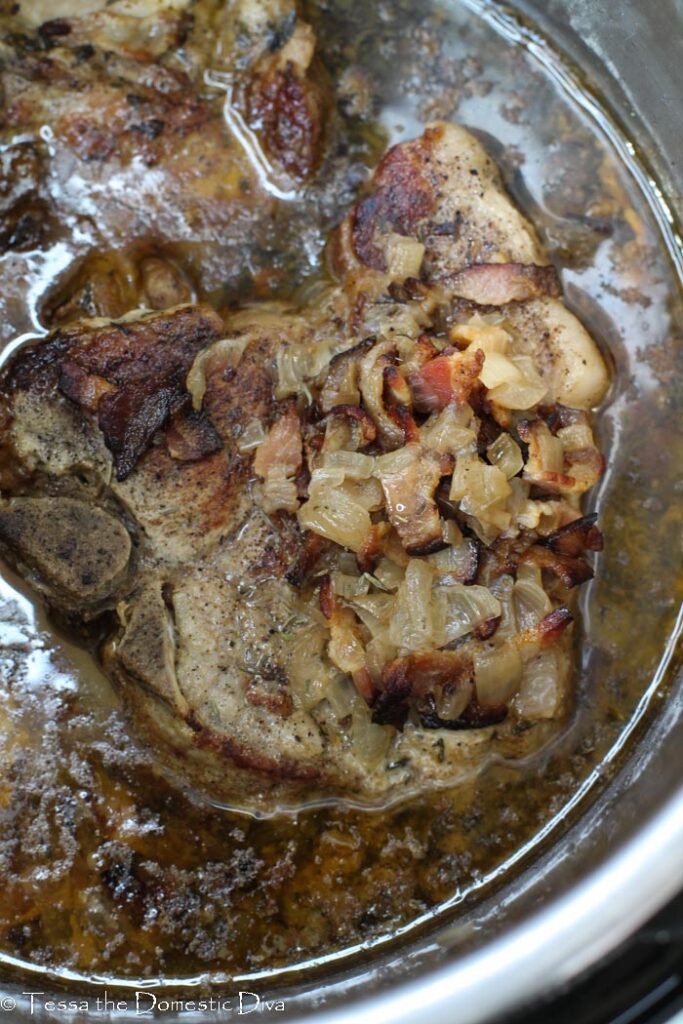 overhead view of pork chops in a Instant Pot insert cooked in a broth.
